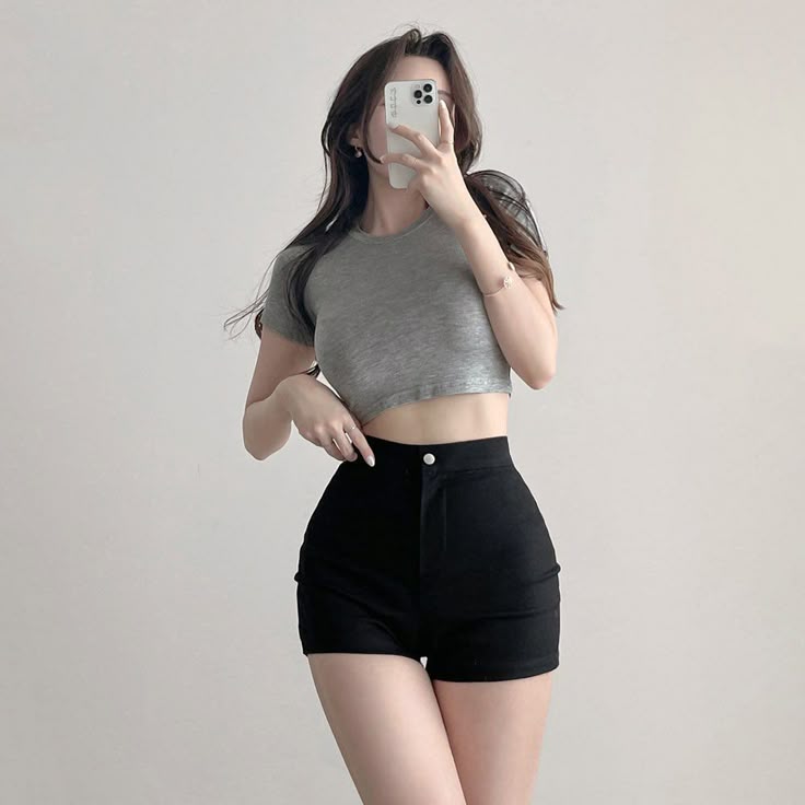 Woman wearing gray crop top and black shorts