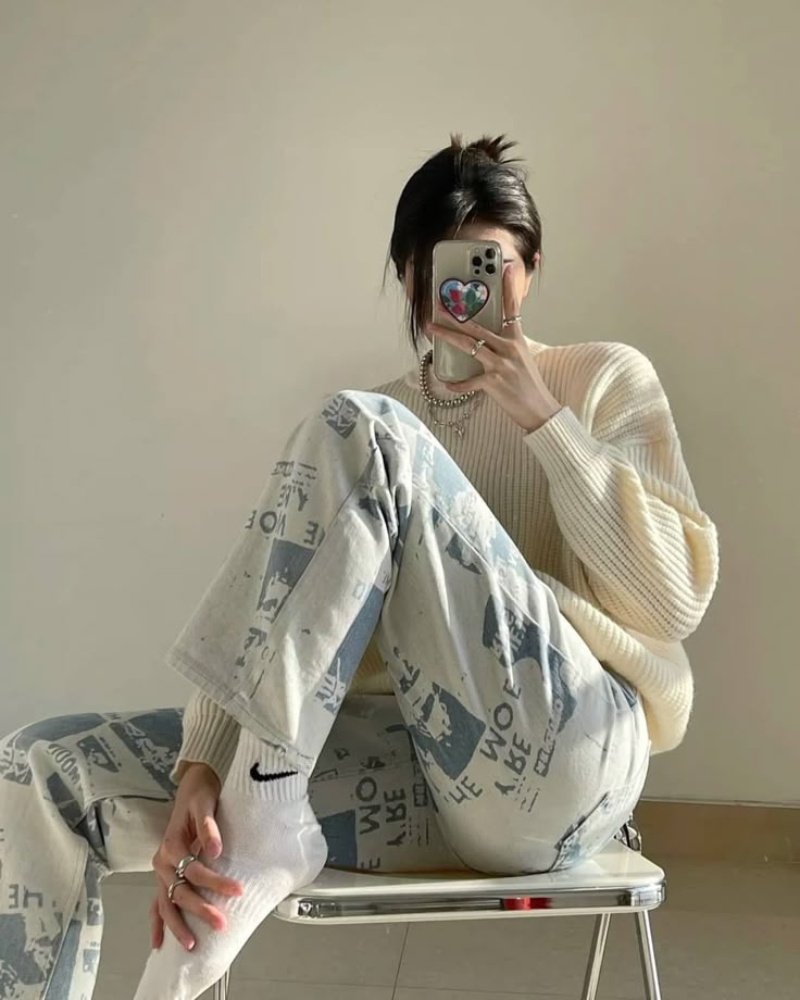 Woman wearing cream knit, graphic pants, and Nike socks fashion styling