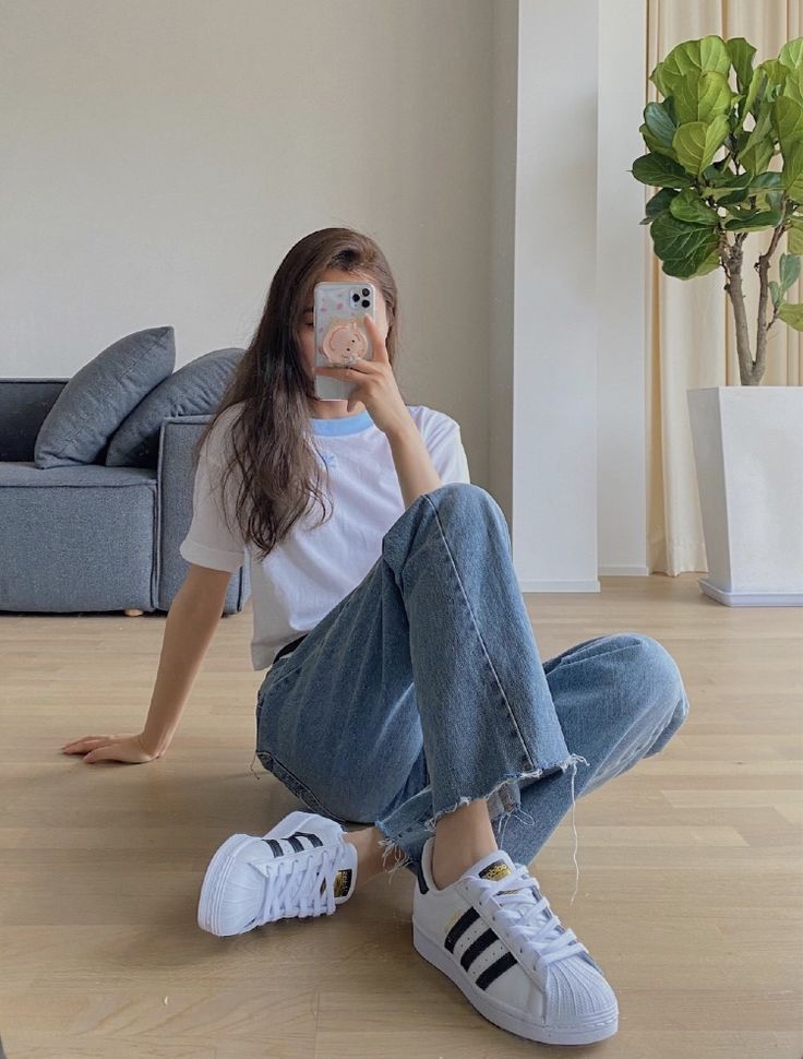 Woman sitting in white t-shirt and denim jeans