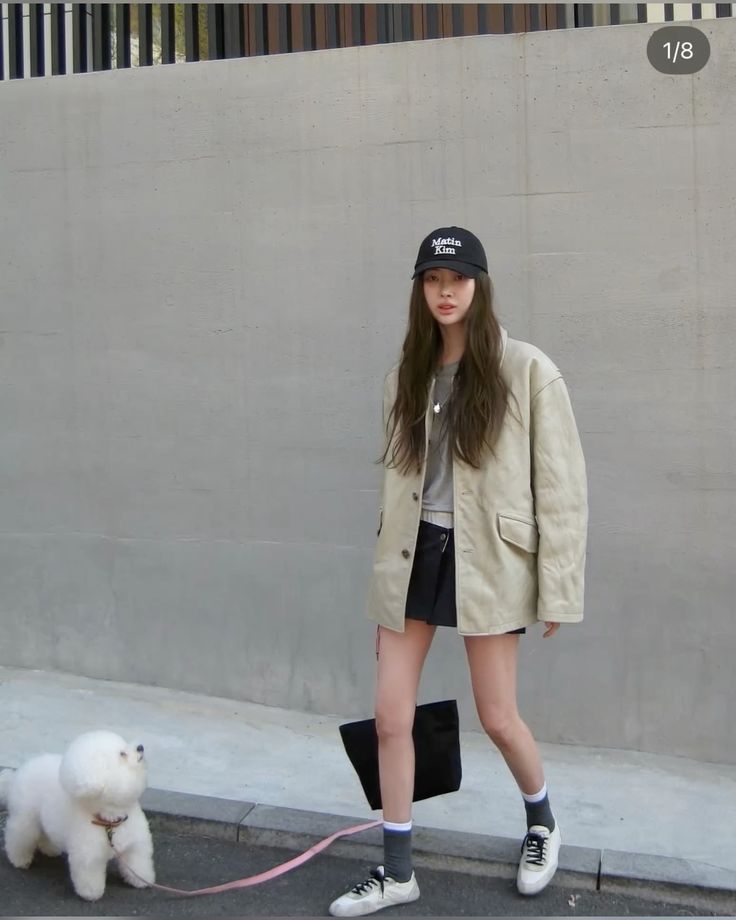 Woman wearing ivory jacket and ball cap in walking outfit