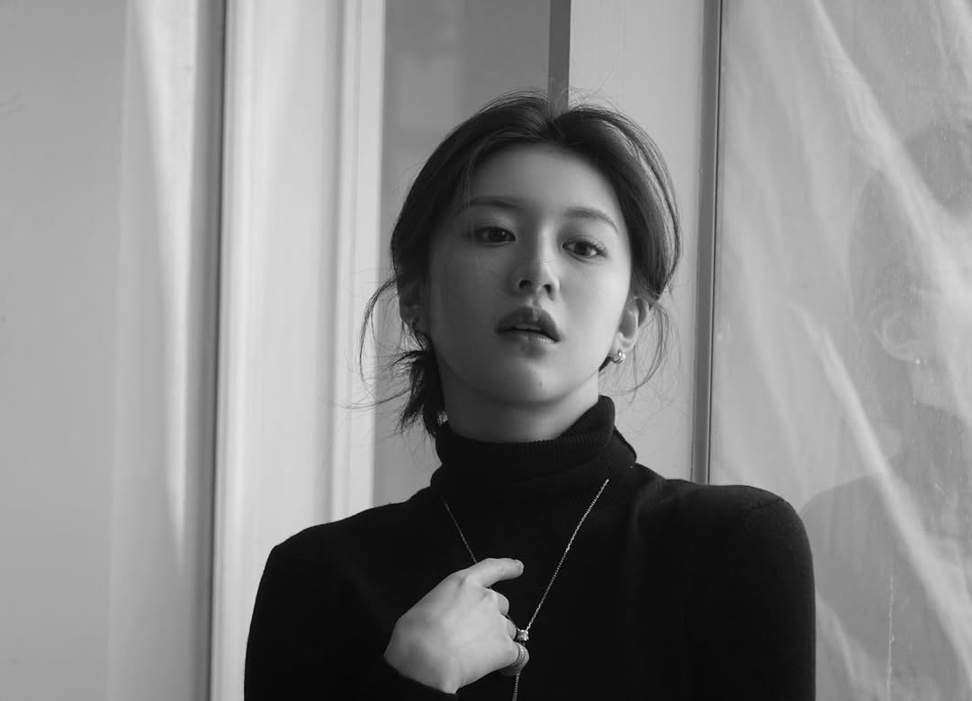 A woman with a natural low bun hairstyle and loose wavy strands softly framing her face