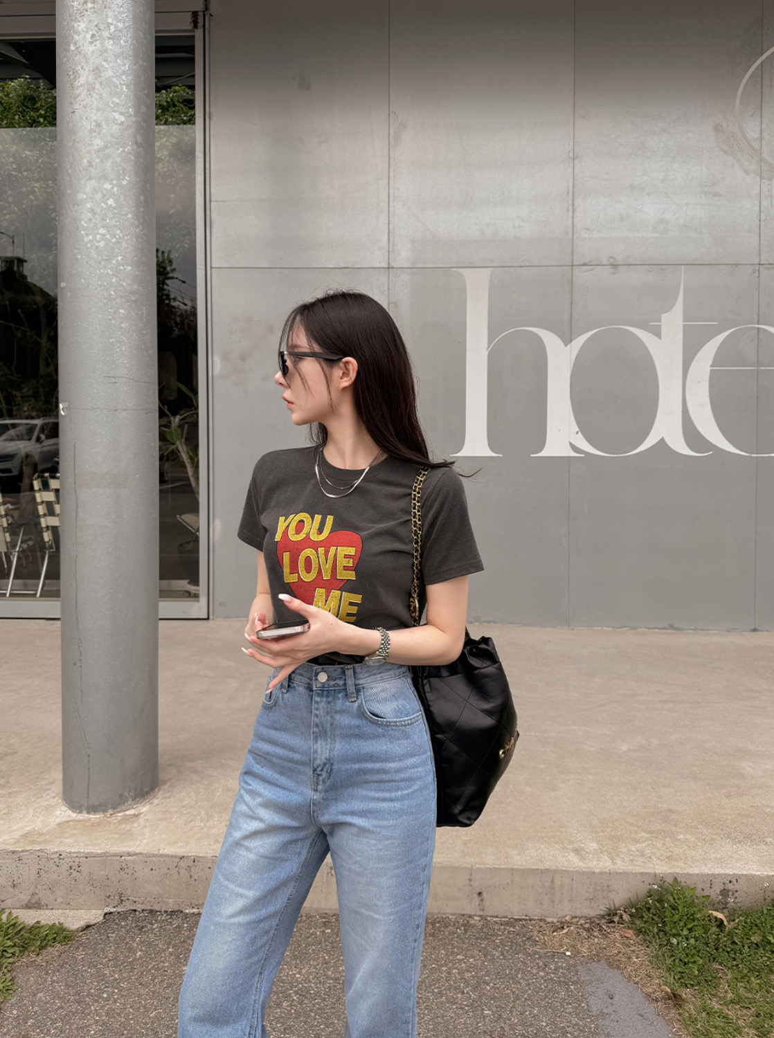 Woman wearing YOU LOVE ME graphic tee with light denim jeans