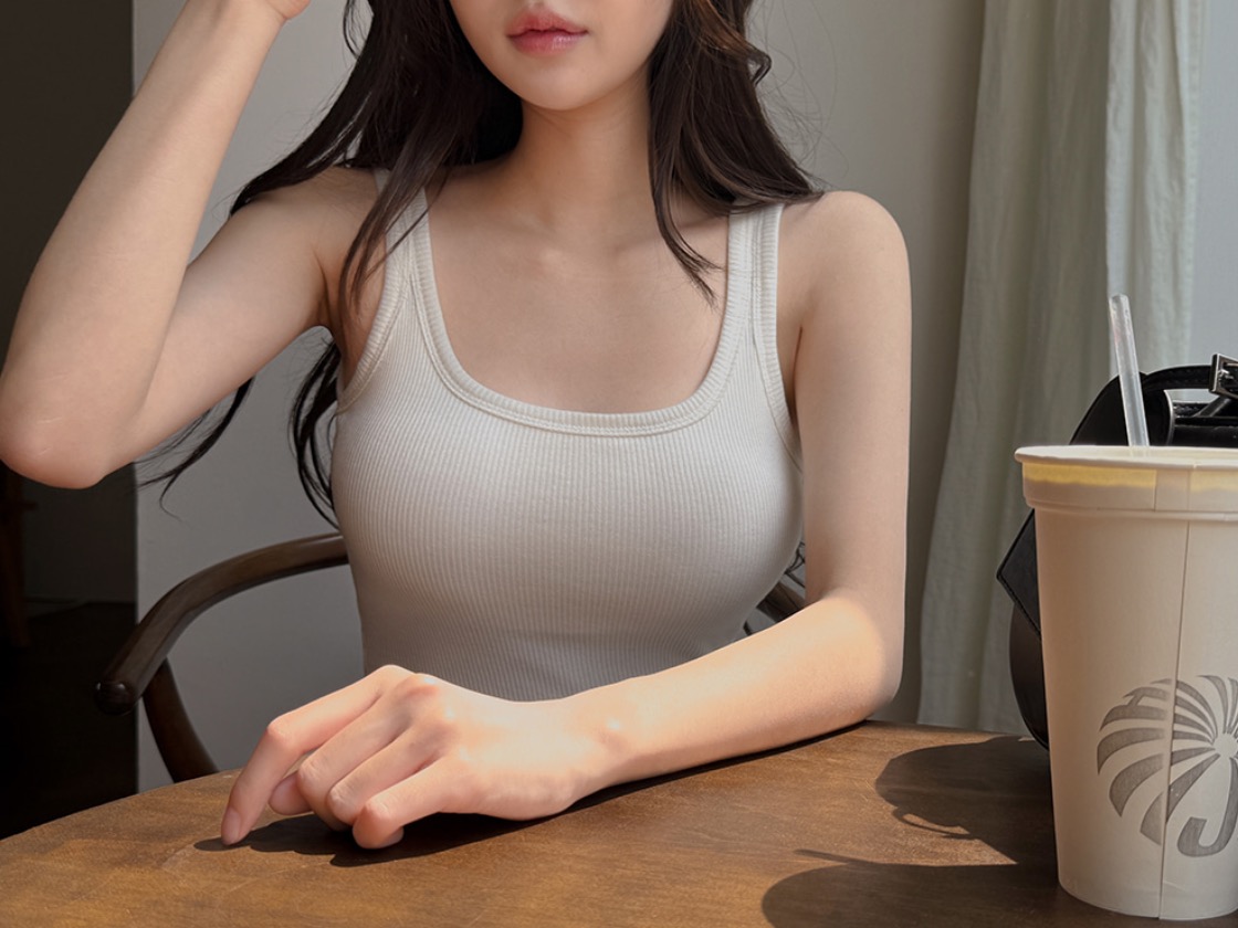Woman wearing white ribbed square-neck sleeveless top