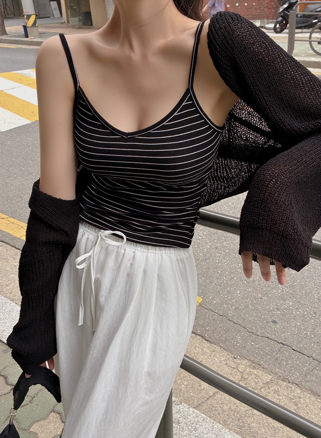 Woman wearing striped sleeveless top and white easy pants