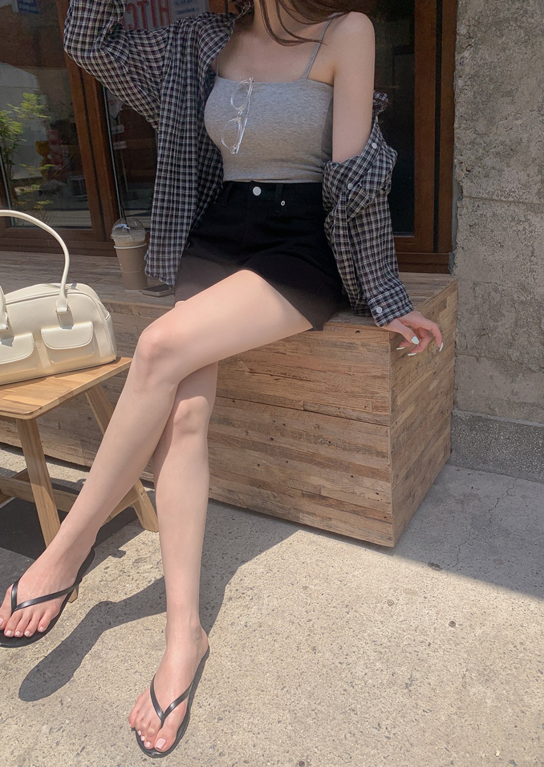 Summer daily look styled with sleeveless top, plaid shirt, and black shorts