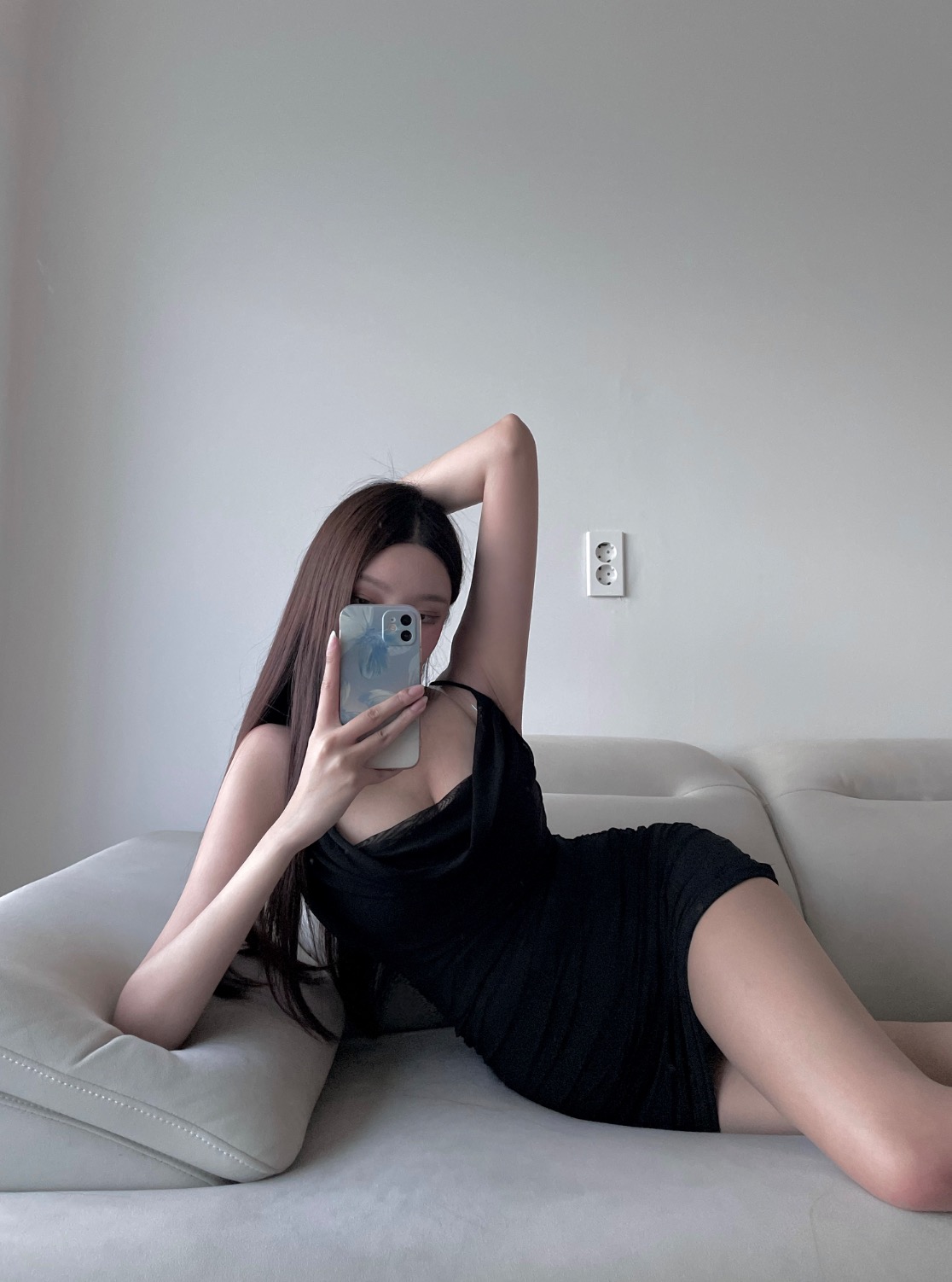 Woman wearing a black or beige draped slip mini dress.