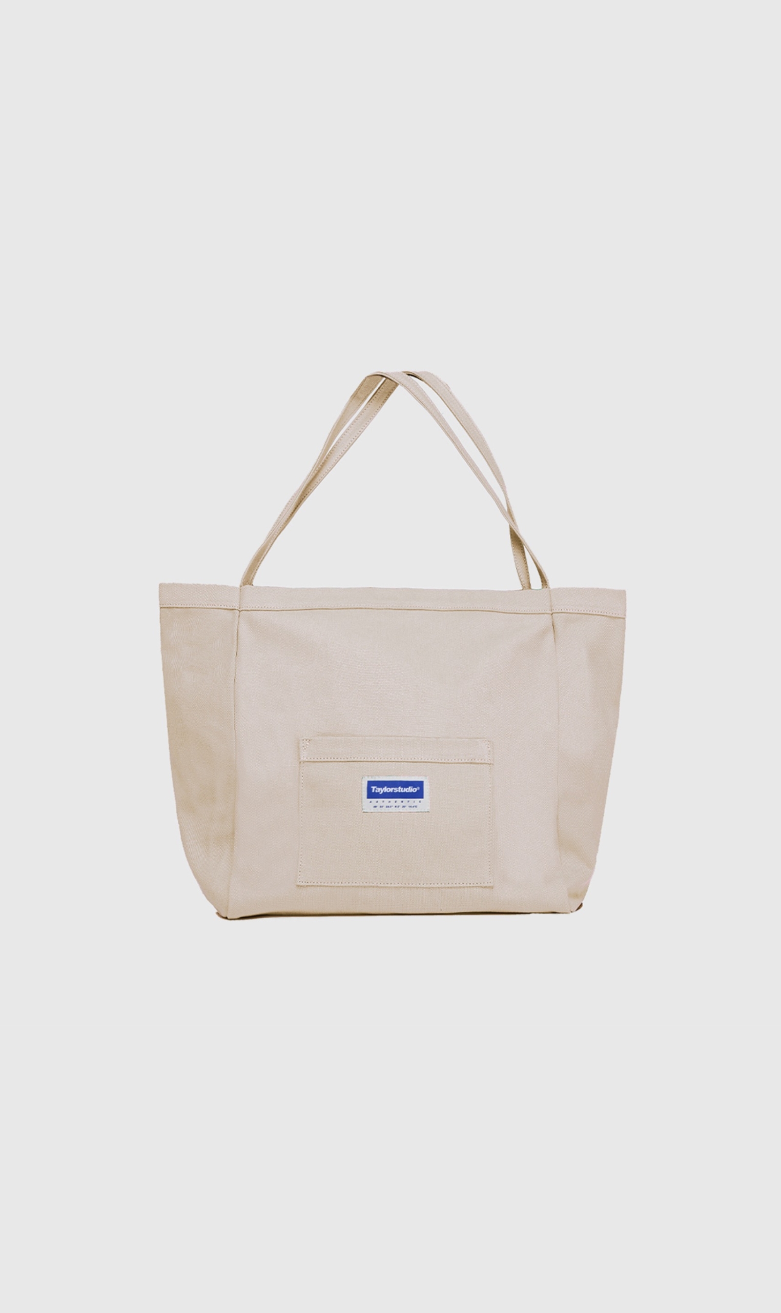 Cream-colored cotton tote bag with front brand label.