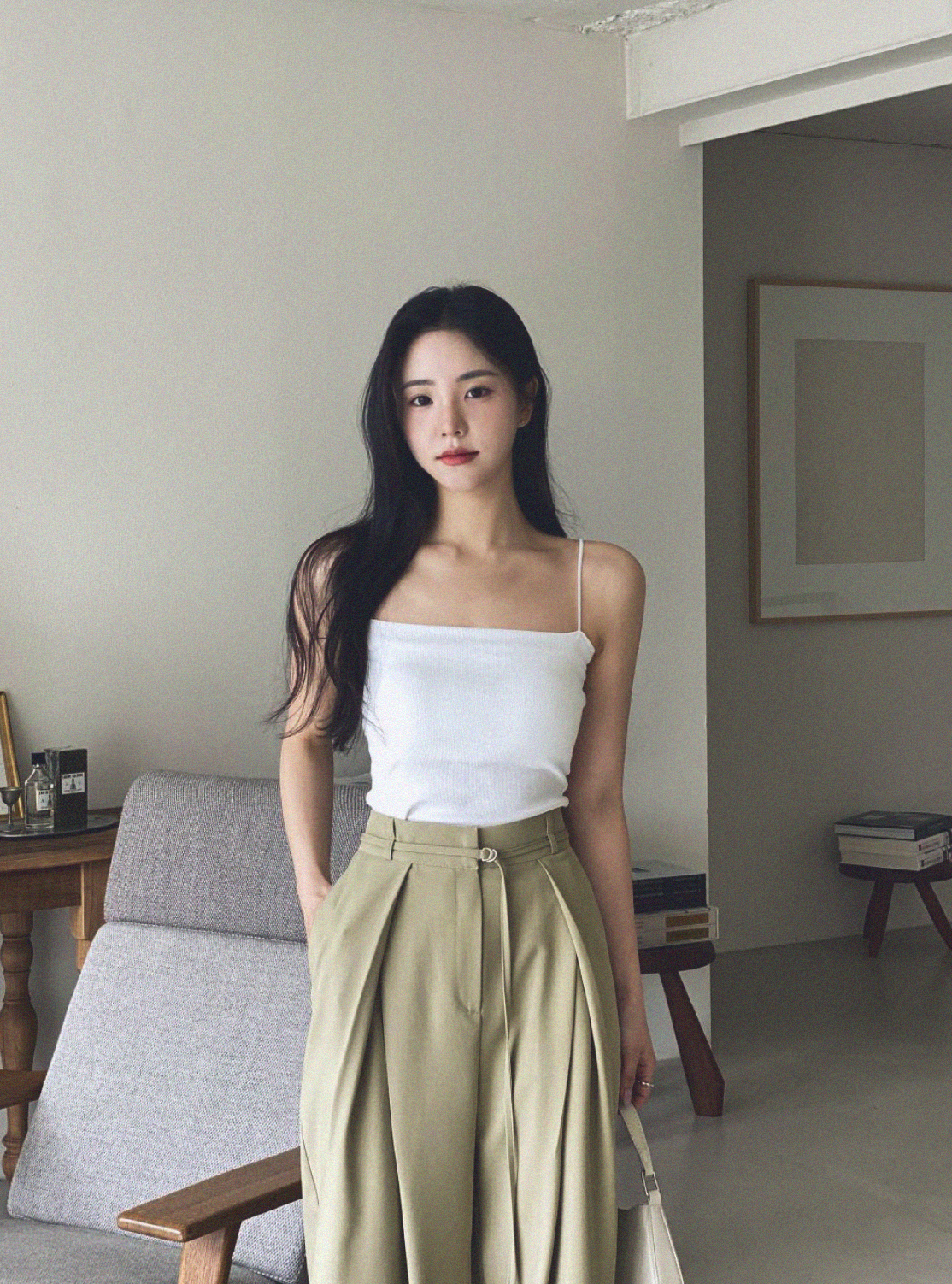 Woman wearing a white sleeveless top and beige wide-leg trousers